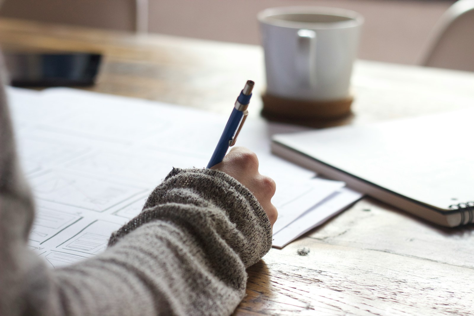 机でノートに書き込みながら勉強する様子